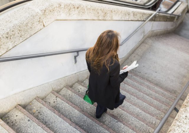 business-woman-with-newspaper-walking-down-stairs (1)