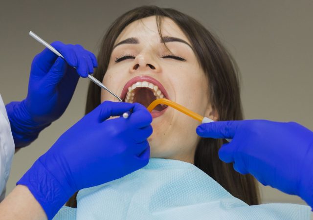 woman-getting-her-teeth-checked-by-dentists (1)